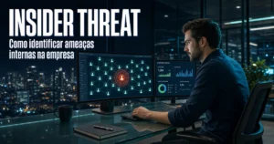 Profissional num escritório à noite a analisar ecrãs de monitorização de segurança que destacam um utilizador em risco numa rede corporativa, ao lado do texto "Insider Threat: Como identificar ameaças internas na empresa".
